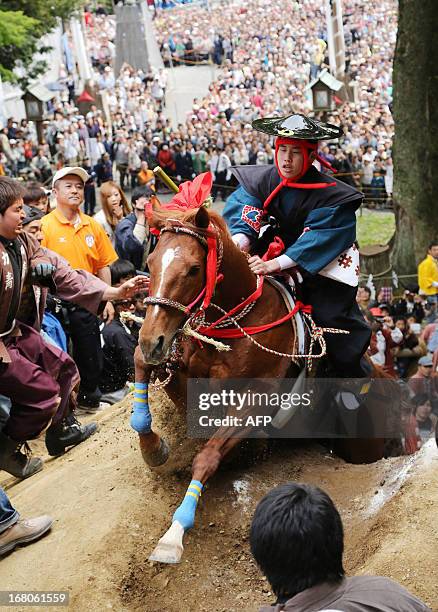 Samurai clad boy riding on a horse surmounts a two meter mud wall during the festival of "Ageuma shinji" at the Tado shrine in Kuwana, in Mie...