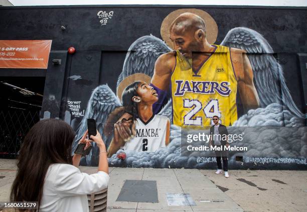 Maria Eastaldo photographs her husband Salvatore Pesante in front of a mural of Los Angeles Lakers legend Kobe Bryant and his daughter Gianna is...