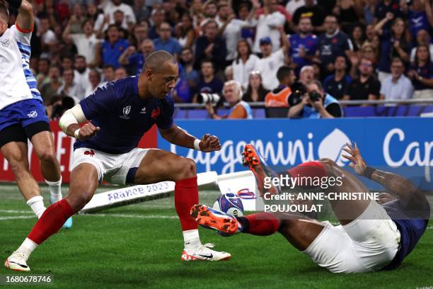 France's inside centre Jonathan Danty rolls to the ground after scoring France's second try infront of France's outside centre Gael Fickou during the...