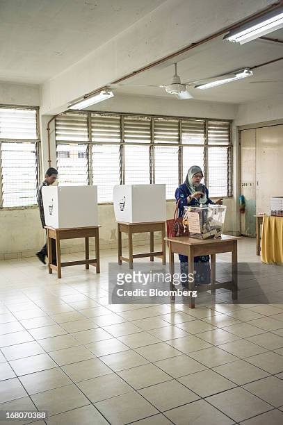 Woman casts her vote at a polling station for the general election in the Kampung Baru area of Kuala Lumpur, Malaysia, on Sunday, May 5, 2013....