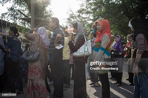 Voters wait in line outside a polling station for the general election in the Kampung Baru area of Kuala Lumpur, Malaysia, on Sunday, May 5, 2013....