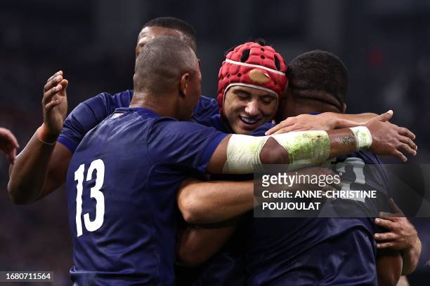 France's inside centre Jonathan Danty is congratulated by France's wing Louis Bielle-Biarrey and France's outside centre Gael Fickou after scoring...