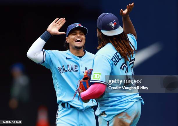 Santiago Espinal of the Toronto Blue Jays celebrates with Vladimir Guerrero Jr. #27 after the final out against the Washington Nationals at Rogers...