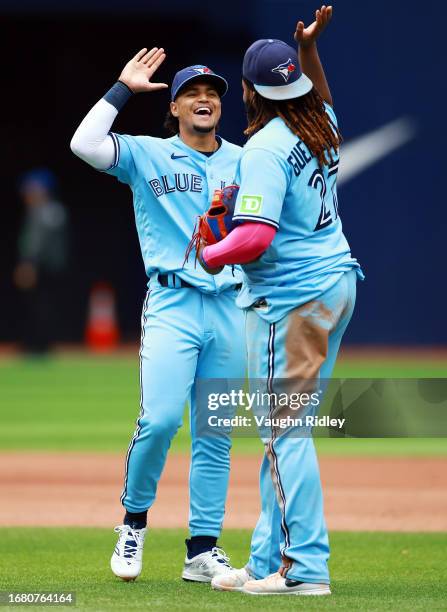 Santiago Espinal of the Toronto Blue Jays celebrates with Vladimir Guerrero Jr. #27 after the final out against the Washington Nationals at Rogers...