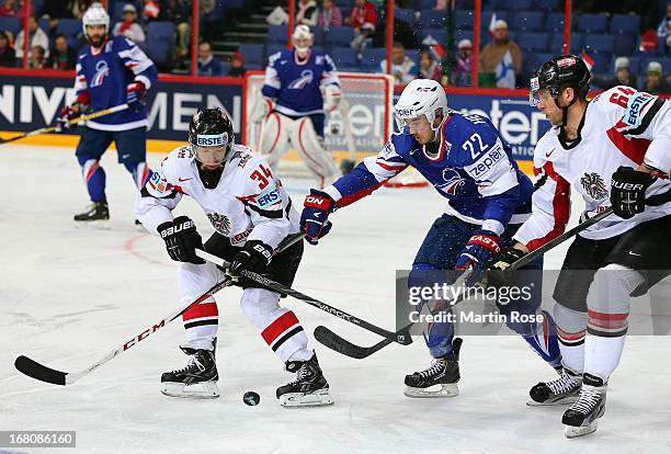 Brian Henderson of France and Markus Peitner and Andre Lakos of Austria battle for the puck during the IIHF World Championship group H match between...