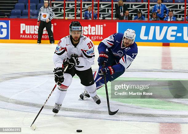 Sacha Treille of France and Martin Schumnig of Austria battle for the puck during the IIHF World Championship group H match between France and...