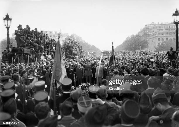 Picture dated of May 8, 1945 showing French general Charles de Gaulle dropping a wreath of flowers off at the Triumphal Arch as Parisians gathered...