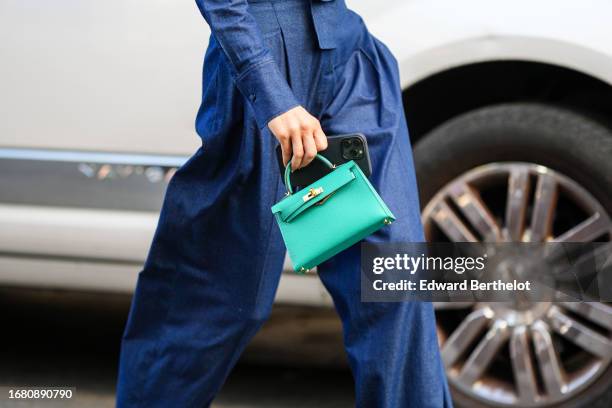 Caroline Daur wears sunglasses, a blue denim jumpsuit, a green Hermes Kelly bag, outside Carolina Herrera, during New York Fashion Week, on September...