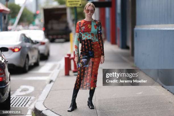 Fashion week guest was seen wearing black shoes, red and brown glasses, a dark but colorful bag and a colorful ling dress with several motives...