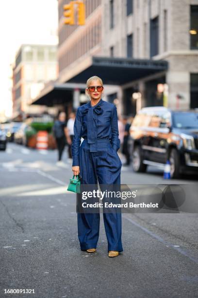 Caroline Daur wears sunglasses, a blue denim jumpsuit with blue lavaliere detail, a green Hermes Kelly bag, golden sequined shoes, outside Carolina...