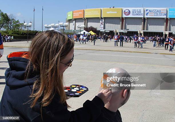 Carianne Varrecchia of Farmingville paints an Islanders logo on James Edmonds of Ronkonkoma prior to Game Three of the Eastern Conference...