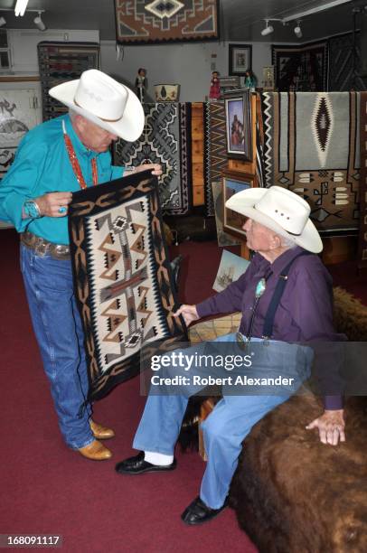 Manager at Richardson's Trading Company & Cash Pawn shows a Navajo rug to the shop's owner, Bill Richardson . The Gallup, New Mexico, landmark on...