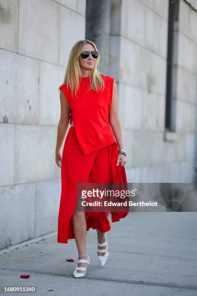 Lisa Aiken wears aviator sunglasses, a red slit midi dress, white pointed shoes, outside Gabriela Hearst, during New York Fashion Week, on September...