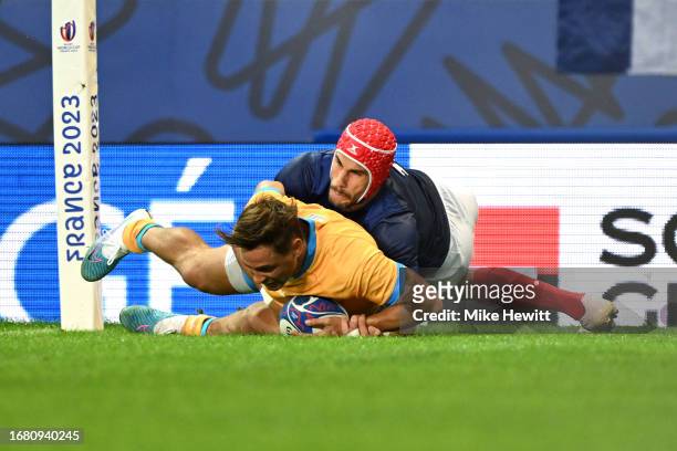 Nicolas Freitas of Uruguay scores his team's first try ahead of Gabin Villiere of France during the Rugby World Cup France 2023 match between France...
