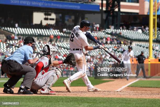 Matt Vierling of the Detroit Tigers hits a eighth inning grand slam home run in front of Tyler Stephenson of the Cincinnati Reds at Comerica Park on...