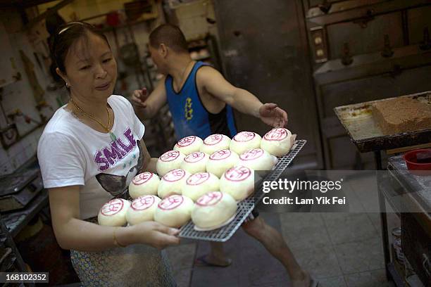 Staff of bakery pass a tray of buns during the selection contest for the finalists of the Cheung Chau Bun Scrambling Competition in Cheung Chau, on...