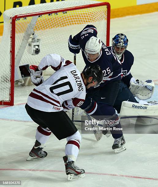 Lauris Darzins of Latvia and Matt Carle of USA battle for the puck during the IIHF World Championship group H match between Latvia and USA at...