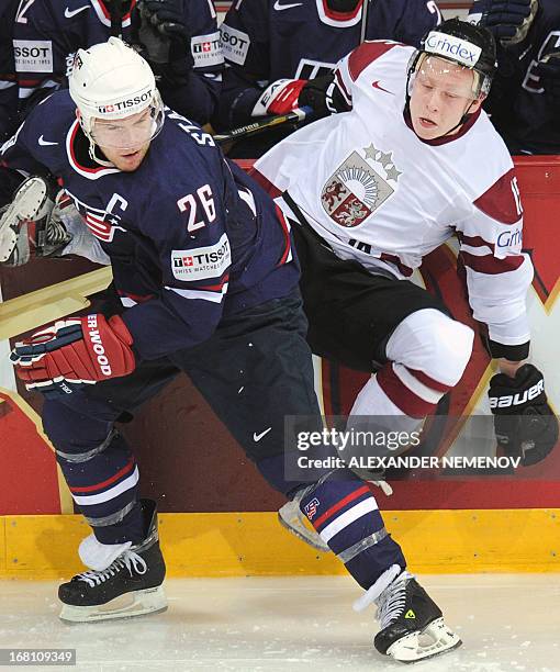 Latvia's forward Ronalds Kenins vies for the puck with US forward Paul Stastny during the preliminary round match Latvia vs United States of the IIHF...