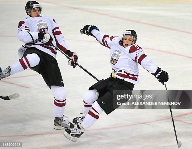 Latvia's forwards Vitalijs Pavlovs and Roberts Jekimovs collide during the preliminary round match Latvia vs United States of the IIHF International...
