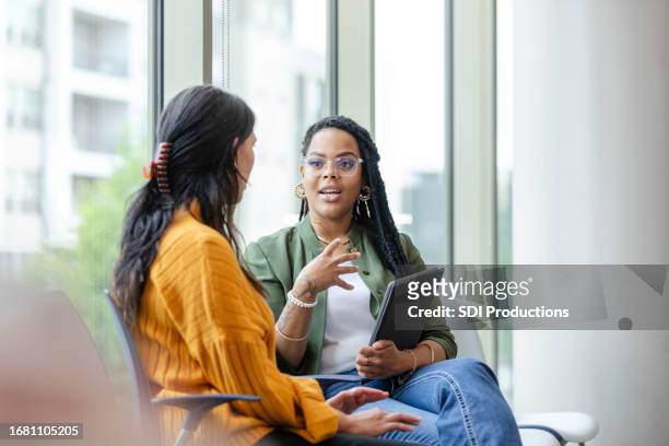 therapy client listens to therapist discuss coping strategy - talk stock pictures, royalty-free photos & images