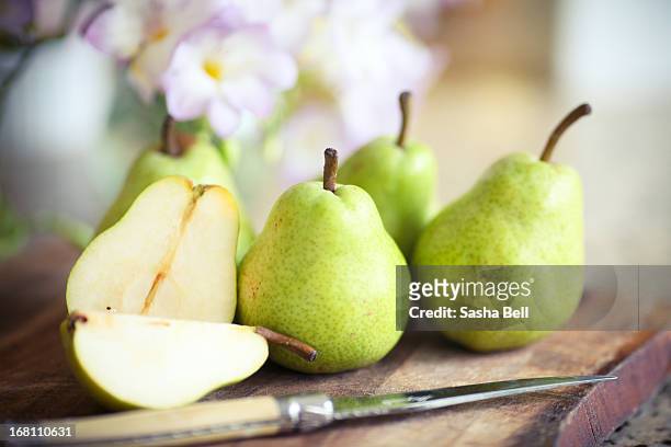 green pears on wooden board - pears stock-fotos und bilder