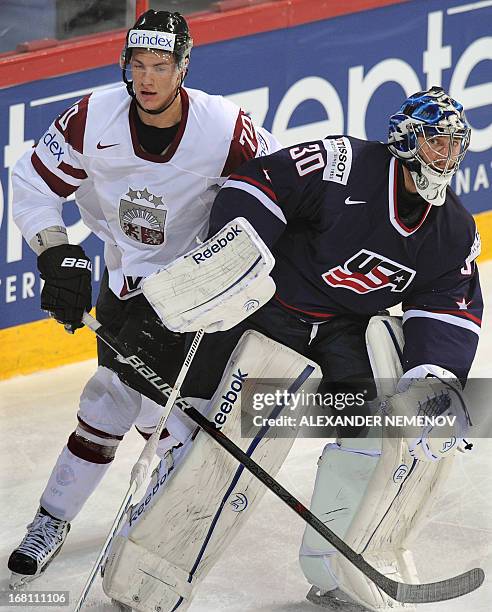 Latvia's forward Miks Indrasis attacks US goalkeeper Ben Bishop during the preliminary round match Latvia vs United States of the IIHF International...