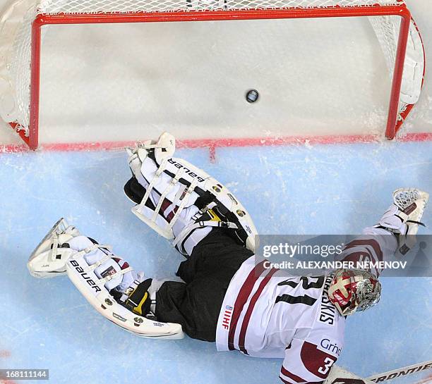 Latvia's goalkeeper Edgars Masalskis tries to catch the puck during the preliminary round match Latvia vs United States of the IIHF International Ice...