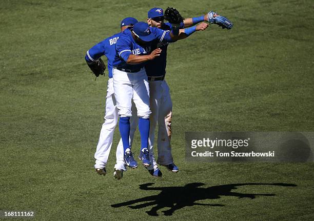 Emilio Bonifacio of the Toronto Blue Jays and Jose Bautista and Rajai Davis celebrate their victory during MLB game action against the Seattle...