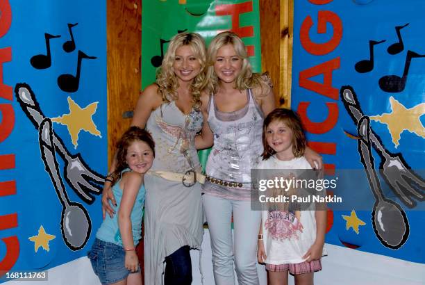 Portrait of American sibling pop musicians and actresses Alyson and Amanda Michalka , who perform as Aly and AJ , as they pose with some young fans...