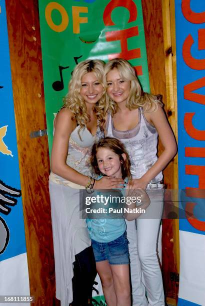 Portrait of American sibling pop musicians and actresses Alyson and Amanda Michalka , who perform as Aly and AJ , as they pose with a young fan...