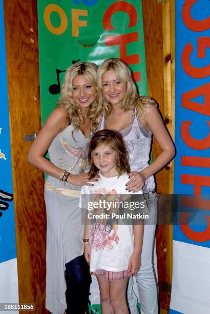 Portrait of American sibling pop musicians and actresses Alyson and Amanda Michalka , who perform as Aly and AJ , as they pose with a young fan...