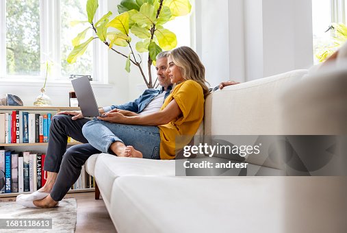 Couple at home booking a reservation online Couple at home booking a reservation online
