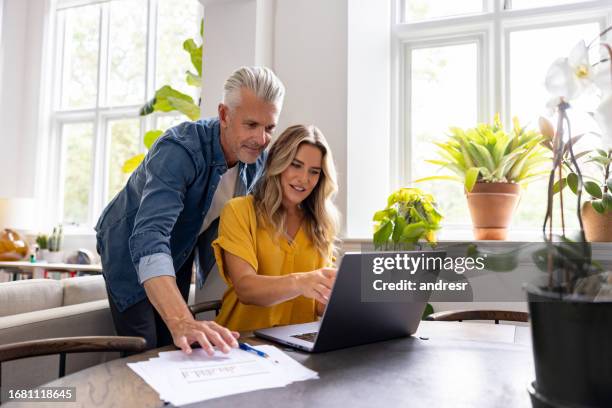 happy couple paying bills online while staying at home - energy bill stock pictures, royalty-free photos & images