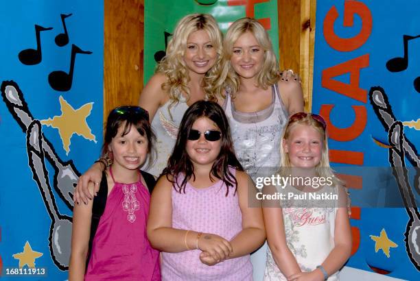 Portrait of American sibling pop musicians and actresses Alyson and Amanda Michalka , who perform as Aly and AJ , as they pose with some young fans...