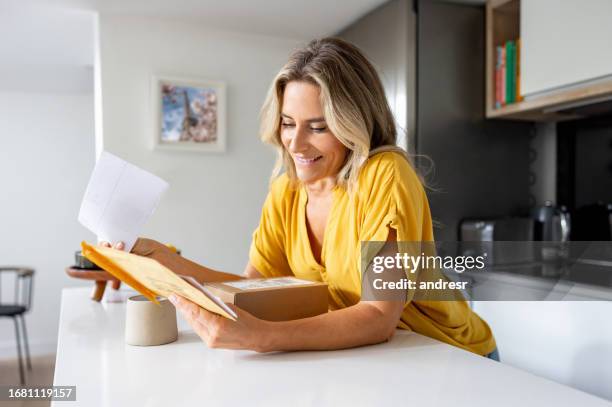 happy woman at home checking her mail - letterbox house stock pictures, royalty-free photos & images