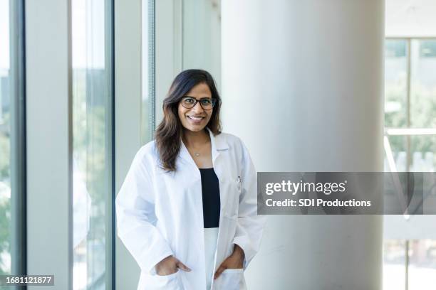 successful female doctor poses for headshot in office - american college of physicians stock pictures, royalty-free photos & images