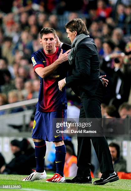 Lionel Messi of Barcelona speaks with Tito Vilanova the Barcelona head coach as he prepares to come off the bench during the La Liga match between FC...