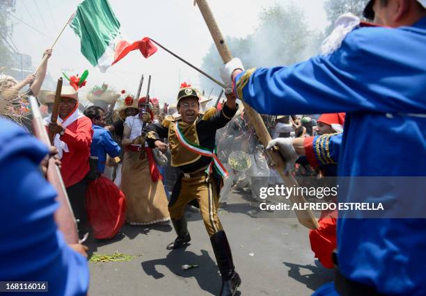 People wear costume along the streets of the Penon de los Banos neighborhood in Mexico City, on May 5 commemorating the anniversary of Mexico's...