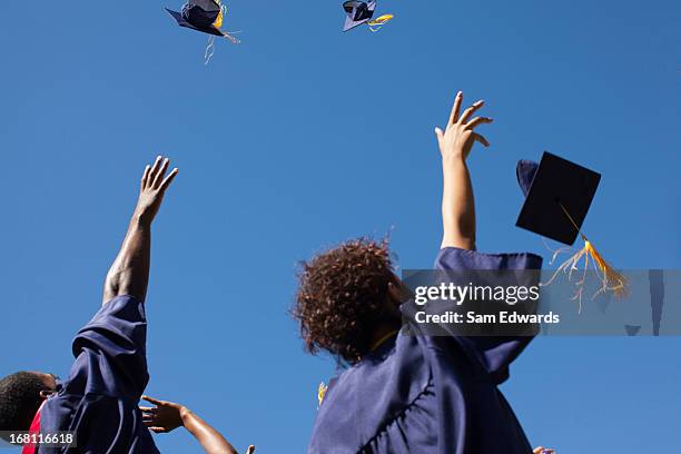 graduates throwing caps in air outdoors - mortar board stock pictures, royalty-free photos & images