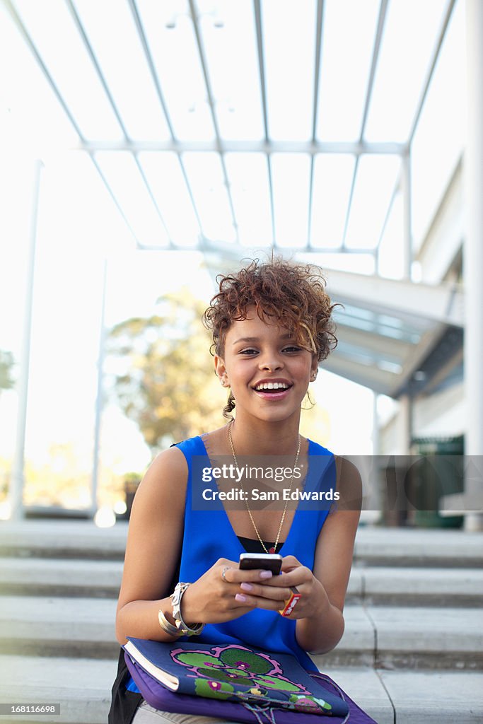 Smiling girl using cell phone