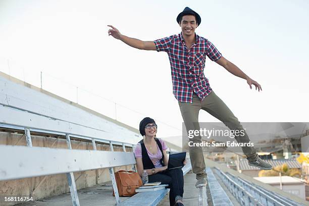 students relaxing on bleachers - on one leg stock pictures, royalty-free photos & images