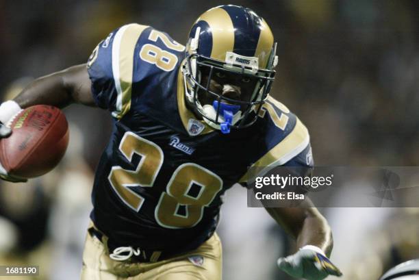 Running back Marshall Faulk of the St. Louis Rams runs the ball against the Oakland Raiders during the NFL game on October 13, 2002 at the Edward...