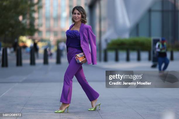 Olga Ferrara is seen wearing silver earrings with green diamonds; a matching outfit from Milly in purple, consisting of a blazer with shoulder pads...