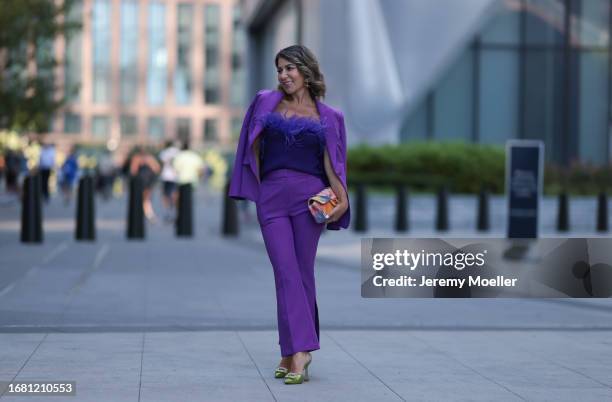 Olga Ferrara is seen wearing silver earrings with green diamonds; a matching outfit from Milly in purple, consisting of a blazer with shoulder pads...