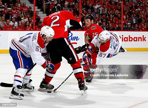 Max Pacioretty of the Montreal Canadiens goes airborne and shoots the puck as Chris Neil and Jared Cowen of the Ottawa Senators defend in Game Three...