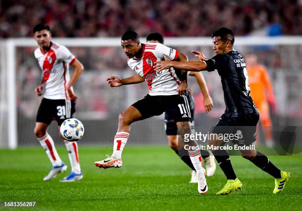 Nicolas De La Cruz of River Plate competes for the ball with Guillermo Acosta of Atletico Tucuman during a match between River Plate and Atletico...