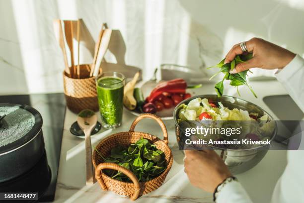 woman mixing bowl of fresh salad. - salad bowl stock pictures, royalty-free photos & images