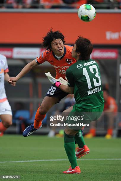 Takamitsu Tomiyama of Omiya Ardija collides with goalkeeper Takuya Masuda of Sanfrecce Hiroshima whilst scoring the second goal during the J.League...