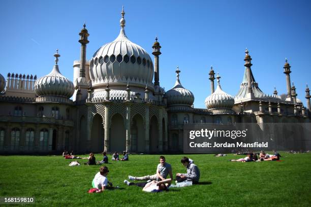 People relax in the sun in the Pavilion Gardens on May 6, 2013 in Brighton, England. Visitors have flocked to Brighton Beach as the Met Office...