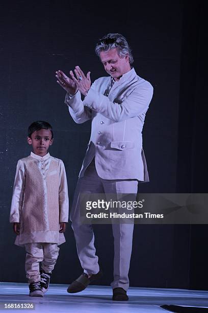 Fashion designer Rohit Bal with a kid at the Annual Charity event Fashion For A Cause organized by NGO Lakshyam to help unprivileged children at...